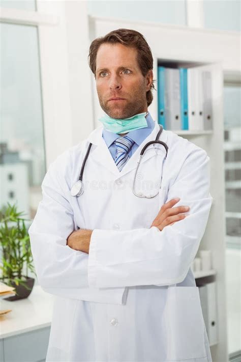 Serious Doctor With Arms Crossed In Medical Office Stock Photo Image