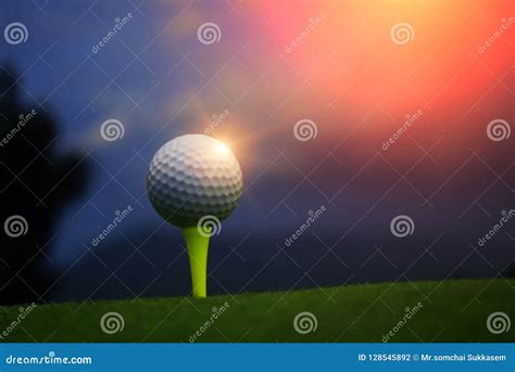 Golf Ball On Tee In Beautiful Golf Course At Sunset Background Stock