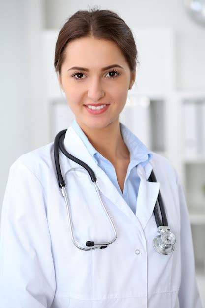 Premium Photo Young Brunette Female Doctor Standing With Arms Crossed