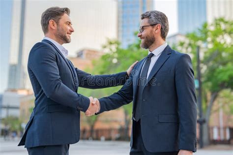 American Businessman Shaking Hands With Partner Two Businessmen