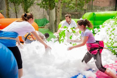 Adultos Recogiendo Bolas En Piscina Inflable Con Espuma Foto De Archivo