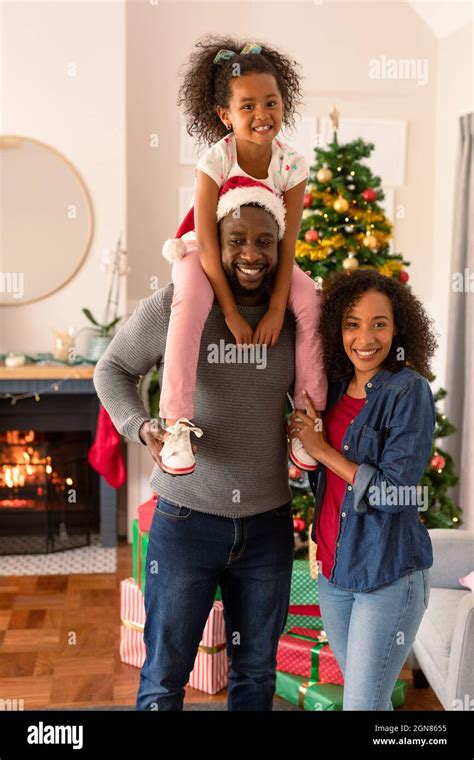 Felices padres afroamericanos y su hija mirando la cámara Tiempo