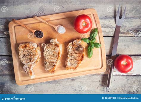 Bifes Grelhados Da Carne De Porco Na Placa De Corte Vista Superior Foto