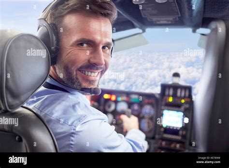 Portrait Smiling Confident Male Pilot Flying Airplane In Cockpit Stock