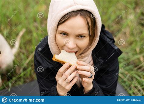 An Adult Attractive Woman Eats A Sandwich Outdoors In The Forest Park