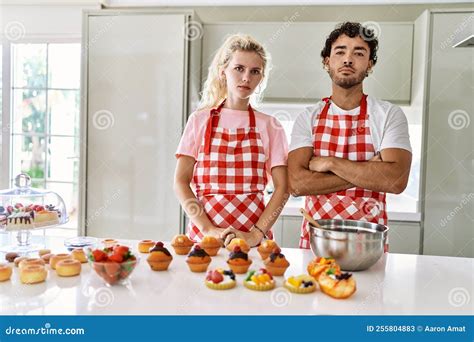 Couple Of Wife And Husband Cooking Pastries At The Kitchen Relaxed With Serious Expression On