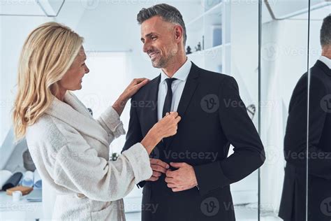 Beautiful Mature Woman Adjusting Necktie Of Her Husband While Both