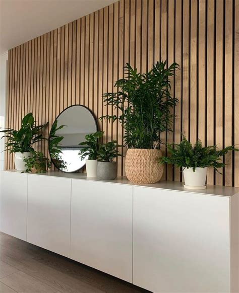 Three Potted Plants Sit On Top Of A White Cabinet In Front Of A Mirror