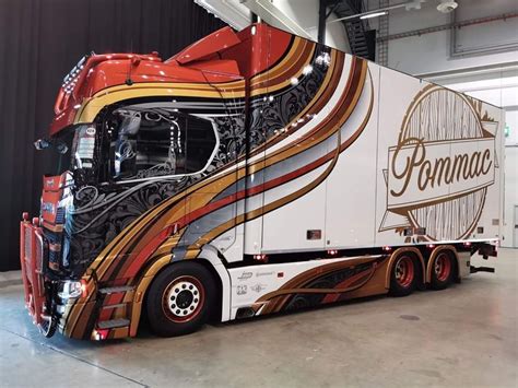 A Large Semi Truck Parked Inside Of A Garage Next To A Black And White Wall