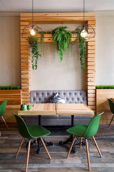 A Table With Green Chairs And Plants On The Wall