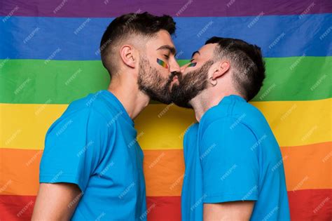 Lgbtの虹色の旗にキスする男性の同性愛者カップル 無料の写真