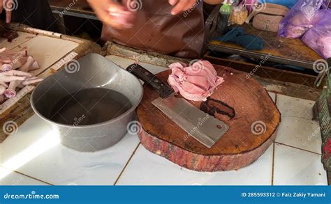 Un Carnicero Cortando Carne De Pollo Con Cuchillas Y Tablas De Madera