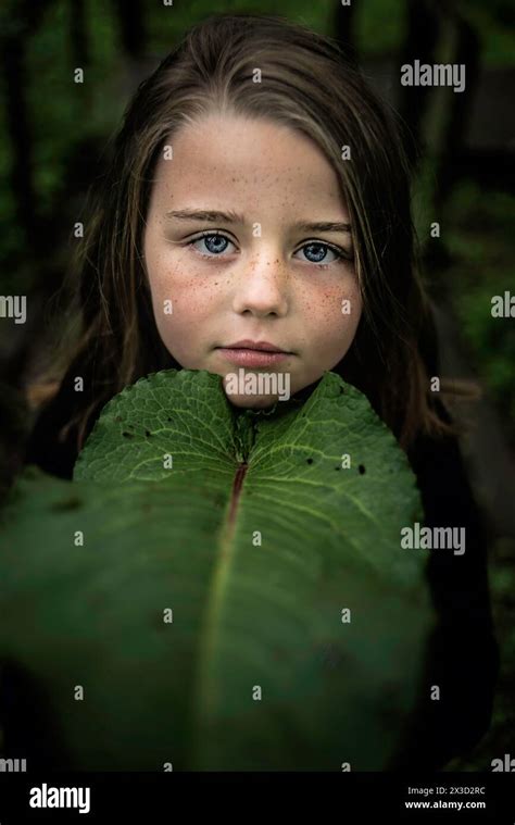 Beautiful Young Girl With Blue Eyes With Giant Green Leaf Stock Photo