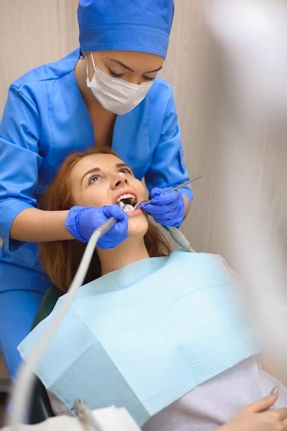 Doutor Em Uniforme Verificando Os Dentes Do Paciente Do Sexo Feminino