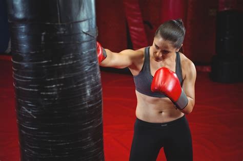 Free Photo Female Boxer Punching A Boxing Bag