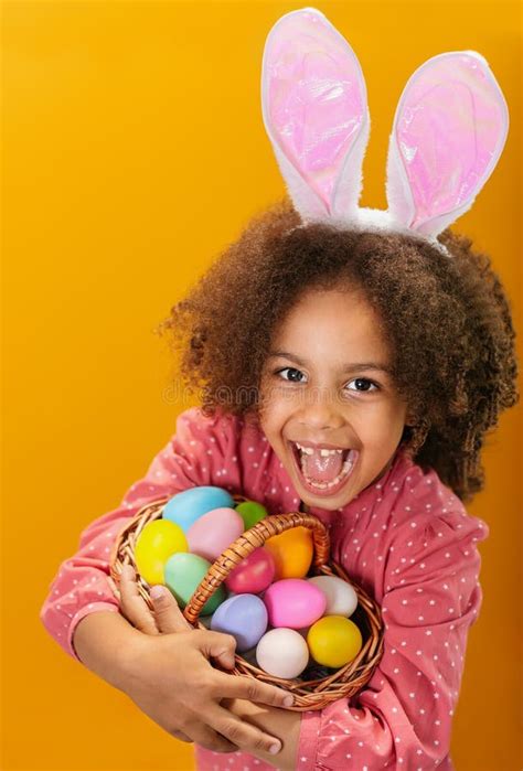 A Black Girl With Rabbit Ears On Her Head With A Basket Full Of Colored