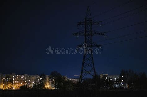 Night View of a Transmission Tower in a Field with Apartment Buildings ...