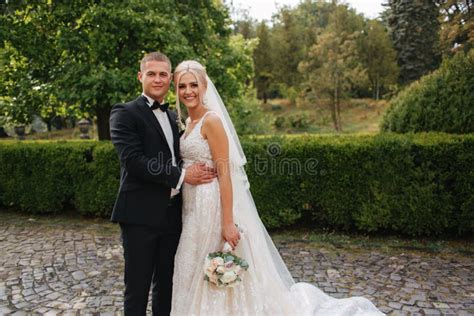 Pares Hermosos De La Boda Que Caminan En El Parque Novia Con El Vestido