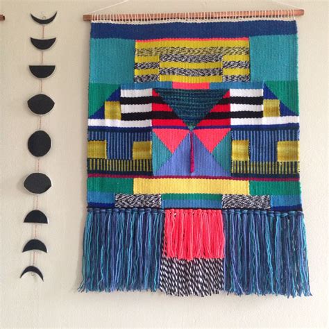 A Wall Hanging Made Out Of Different Colored Fabrics And Fringes With