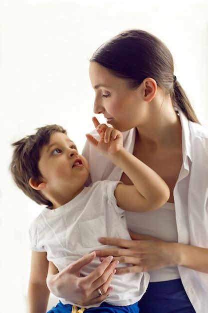 Mamá e hijo están sentados con una camisa blanca y una camiseta junto a