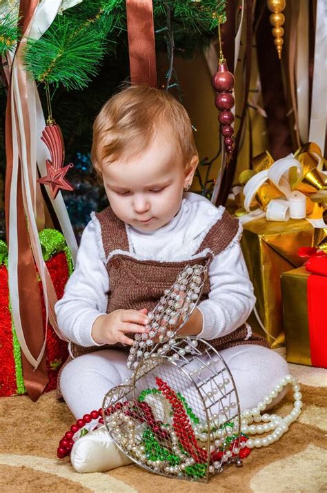 Bebé Que Se Sienta Debajo Del árbol De Navidad En Sitio Imagen de