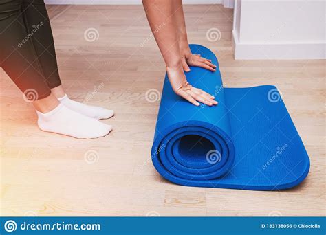 Close Up Of Woman Folding Blue Yoga Or Fitness Mat After Working Out At