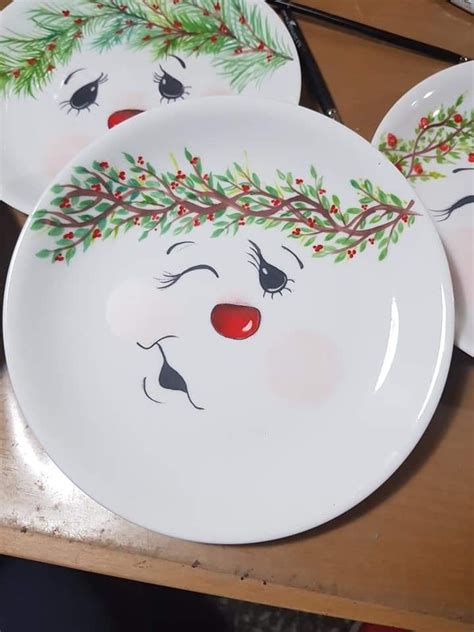 Three White Plates With Christmas Decorations Painted On The Faces And