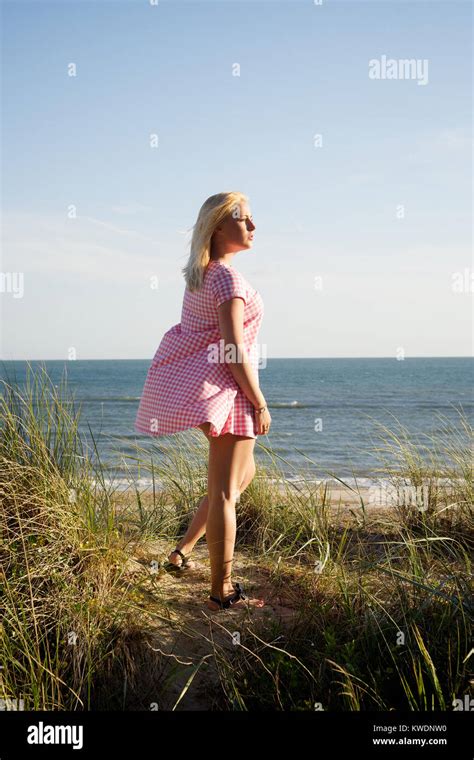 Hübsches Blondes Mädchen Trägt Ein Rosa Kleid In Den Dünen Am Strand Stockfotografie Alamy