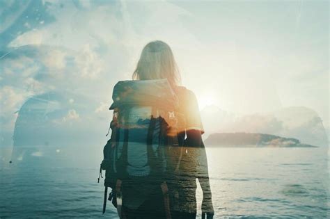 A Woman With A Backpack Standing In Front Of A Body Of Water Premium