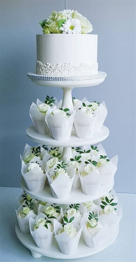 A Three Tiered Cake With White Flowers On It