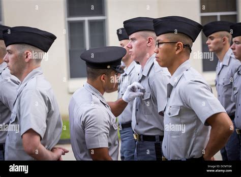 An upperclassman adjusts the new uniforms of Citadel freshmen known as ...