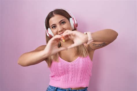 Young Blonde Woman Listening To Music Using Headphones Smiling In Love