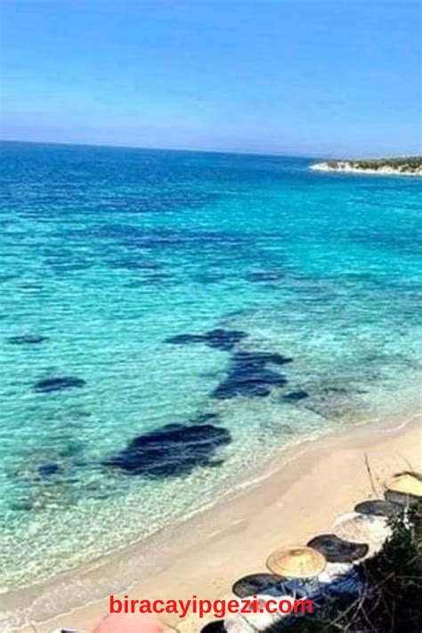 The Beach Is Clear And Blue With Umbrellas On It