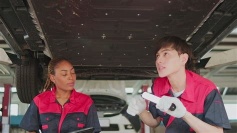 Two professional automotive worker partners discuss mechanical check