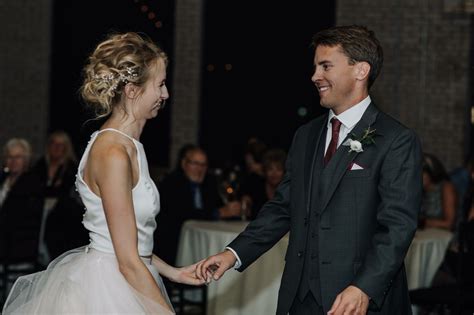 A Bride And Groom Hold Hands At Their Wedding Reception