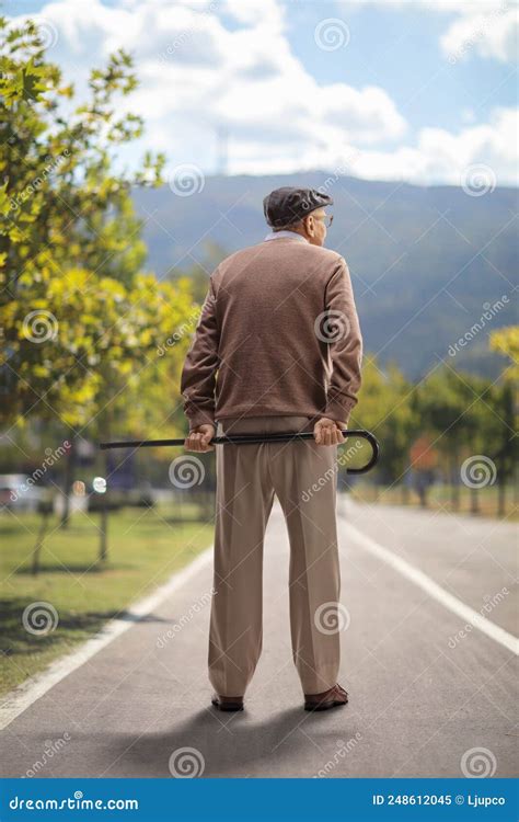 Elderly Man Standing And Holding A Cane Behind His Back Outdoors Stock Image Image Of Male