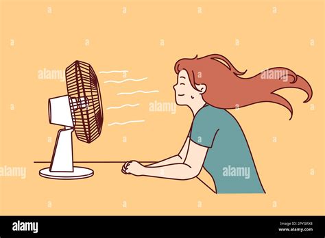 Woman Sitting In Front Of Fan Enjoying Cold Wind After Walking In Hot Summer Weather Or Doing