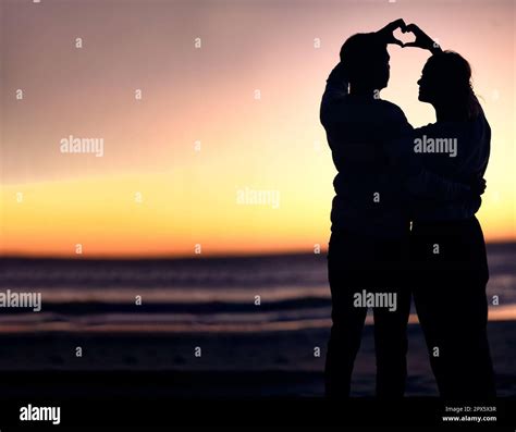 Couple Silhouette And Sunset Beach With Heart Shape Hands For Love