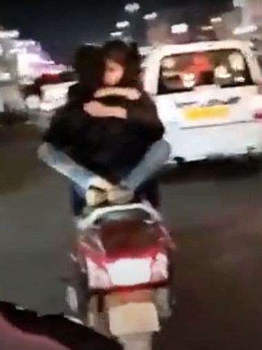 बीच सड़क चलती स्कूटी पर लड़के की गोद में बैठ लड़की ने किया Kiss