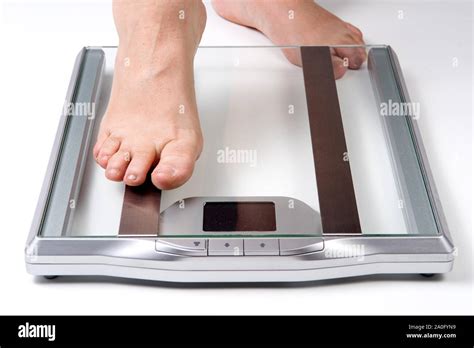 Female Feet Stepping On Electronic Scales For Weight Control On White