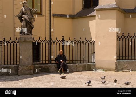 Old lady babushka sitting in downtown city center feeding pigeons in ...