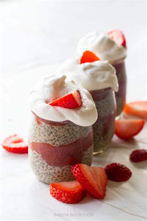 Two Jars Filled With Pudding And Topped With Strawberries