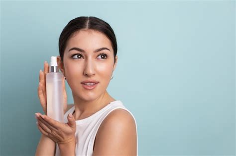 Premium Photo Woman Holding A Bottle In Her Hand And Spraying Liquid