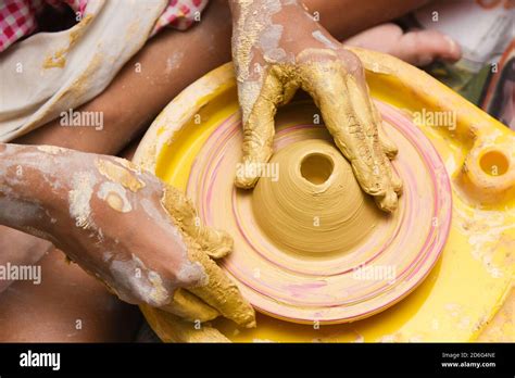 Child Learning To Make Pottery On Potters Wheel Creating Pots By