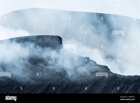 Sulfur gas coming out of the dark edge of the active volcano crater Stock Photo - Alamy