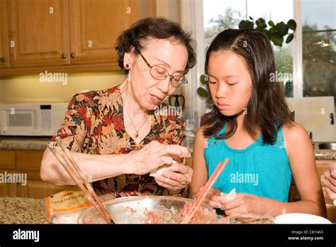 Chinese Grandmother Cooking With Granddaughter Stock Photo Alamy