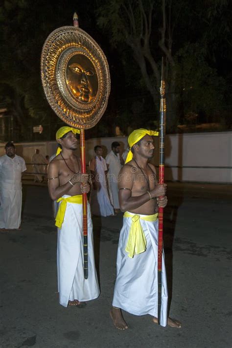 A Spear Carrier Walks Ahead Of A Gilded Sun Disc Carrier Along A Street