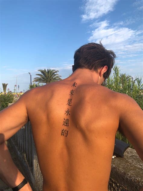 The Back Of A Man With Chinese Writing On His Upper And Lower Back