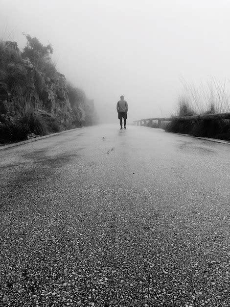 Premium Photo Rear View Of Man Walking On Road During Foggy Weather