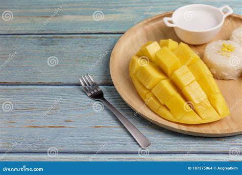 Yellow Half Mango With Small Fork Mango Fruit Cubes On The Blue Wooden